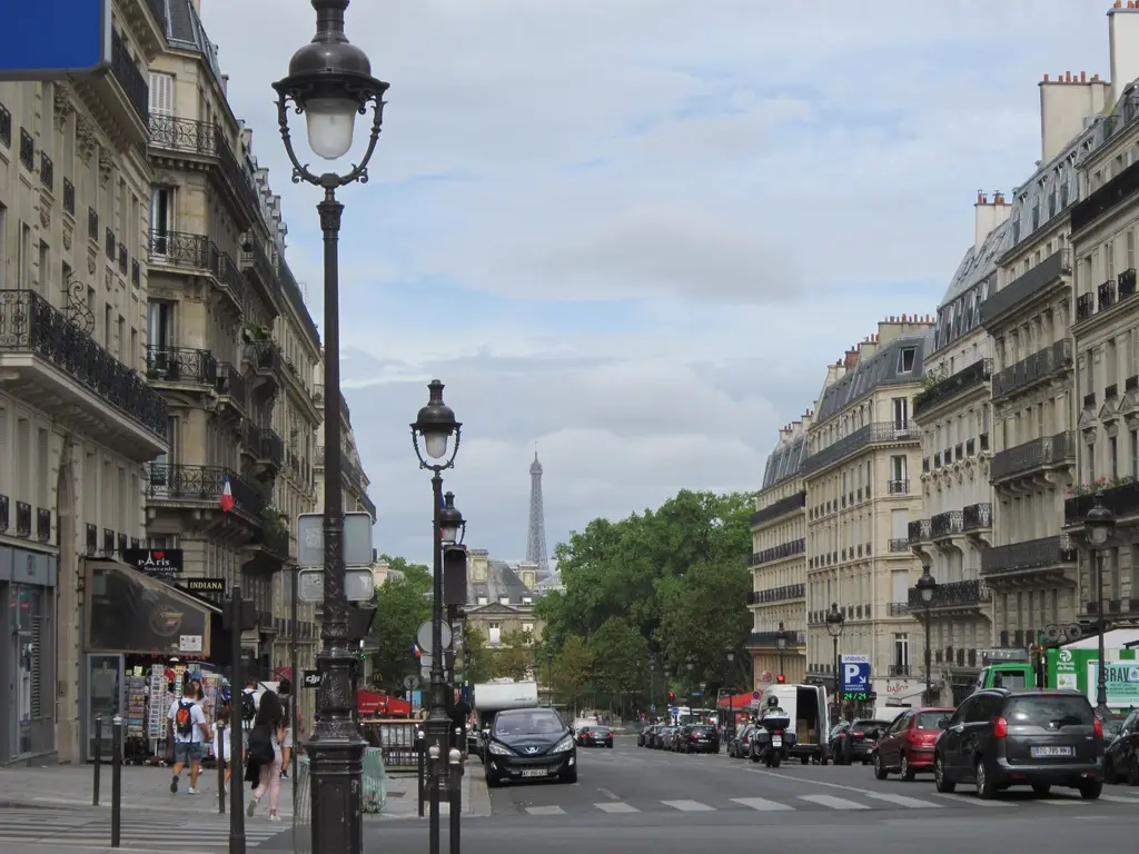Avenue bordée d’immeubles avec la tour Eiffel au loin