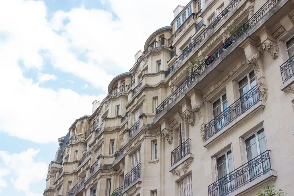 Immeuble parisien en pierre de taille sous un ciel bleu